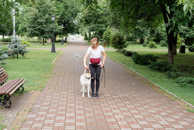 Young caucasian woman training her dog in a park. dog obedience training