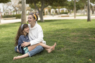 Happy young woman sitting on field