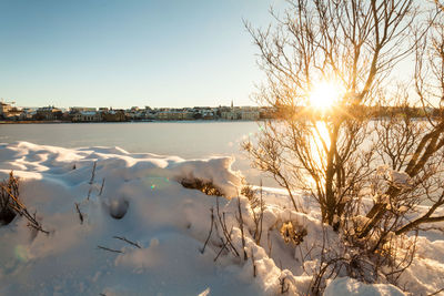 Frozen lake against sky during sunset