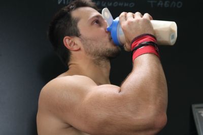 Close-up of shirtless man drinking drink