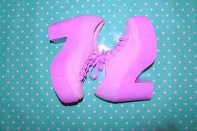 Close-up of pink shoes over white background