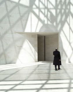 Rear view of a person walking on corridor of building