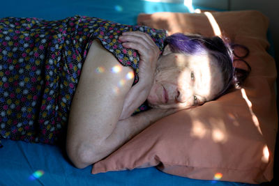 Portrait of senior woman relaxing on bed at home