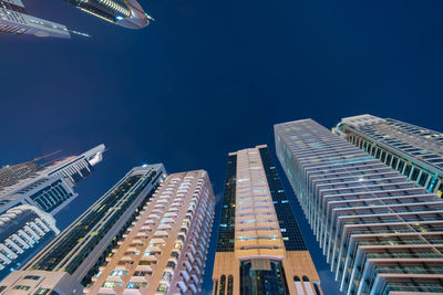 Low angle view of illuminated buildings against clear sky at night