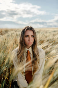 Portrait of young woman standing on field