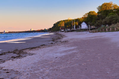 Scenic view of beach against clear sky at sunset