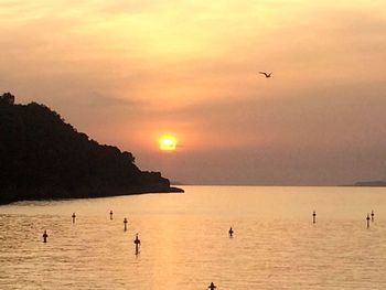 Scenic view of sea against dramatic sky during sunset