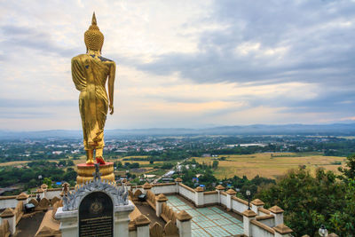 Statue of liberty amidst buildings against sky