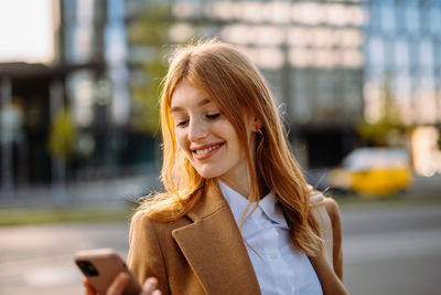 Portrait of young woman standing in city