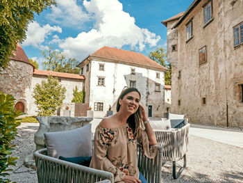Portrait of happy young woman inside a castle courtyard.