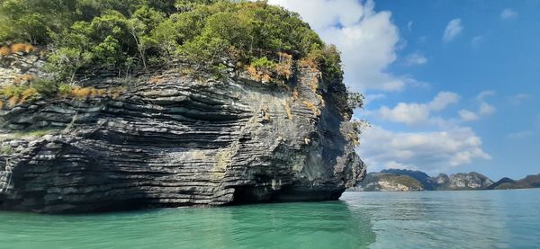 Rock formation in sea against sky