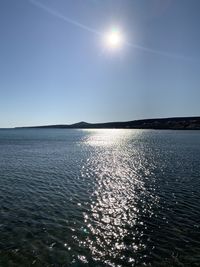 Scenic view of sea against clear sky on sunny day