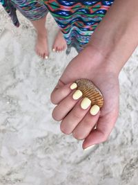 Close-up of woman holding hands on sand