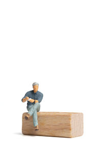 Man sitting on wooden table against white background