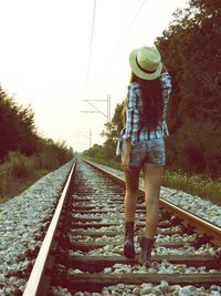 Man standing on railroad tracks against clear sky