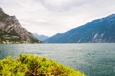 Scenic view of sea by mountains against sky