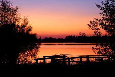 Scenic view of lake against orange sky