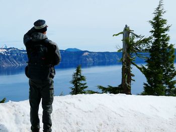 Man standing on snow covered mountain against clear sky