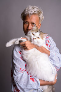 Portrait of man holding camera against black background