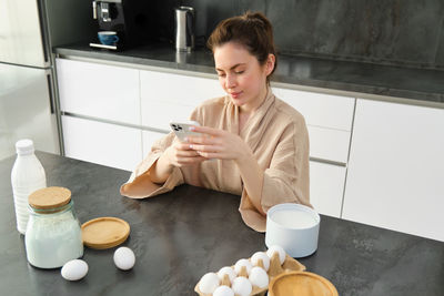 Young woman having food at home