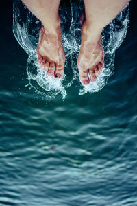 Low section of person legs in swimming pool