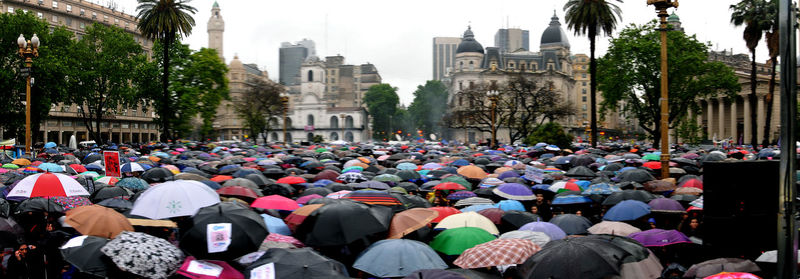 Crowd in city against sky