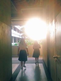 Rear view of women standing in corridor