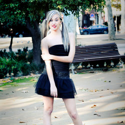 Portrait of beautiful young woman standing at public park