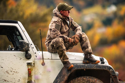 Low section of man standing in car