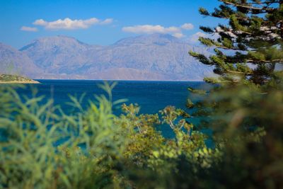 Scenic view of sea and mountains against sky