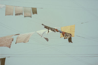 Low angle view of clothes drying on clothesline against sky