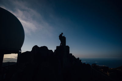 Low angle view of silhouette statue against sky