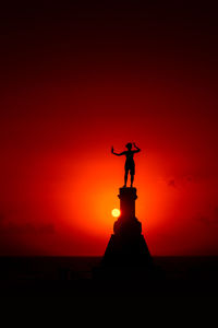 Low angle view of silhouette statue against sky during sunset