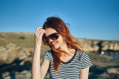 Midsection of woman wearing sunglasses against sky