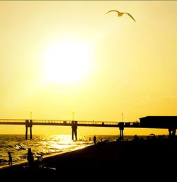 Silhouette of bridge over sea during sunset