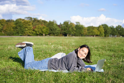 Portrait of young woman sitting on field