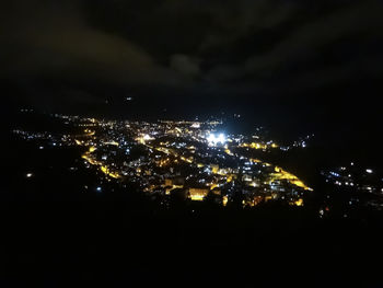 Illuminated cityscape against sky at night