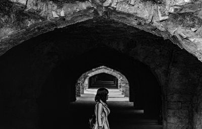 Rear view of woman standing by old building