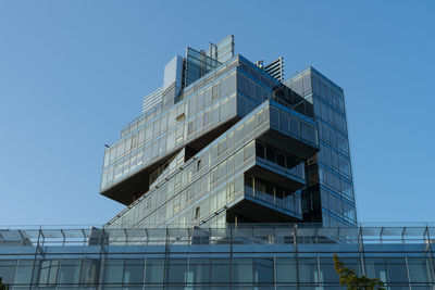 Low angle view of modern building against clear blue sky