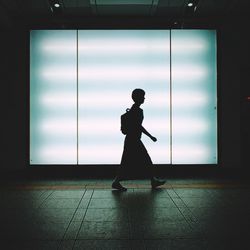 Silhouette man standing on floor against window