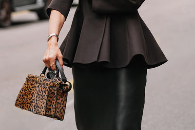 Midsection of woman holding bag