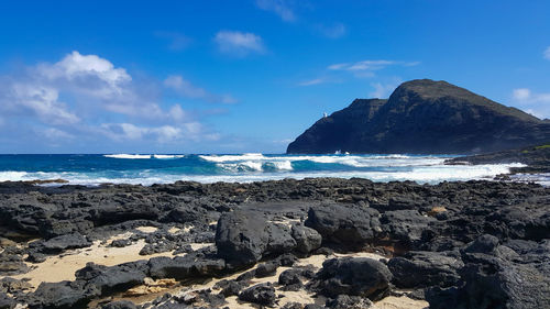 Scenic view of rocks on beach against sky