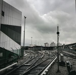 Railroad tracks in city against sky