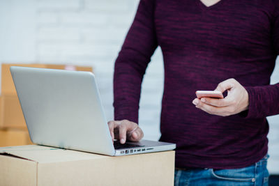 Midsection of man using mobile phone