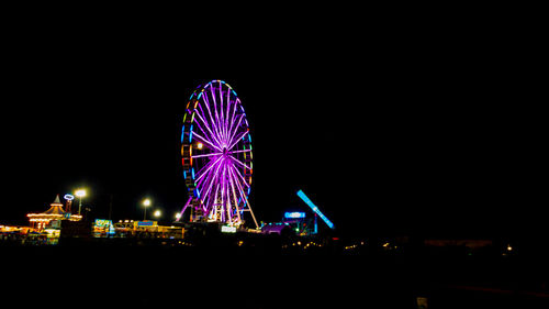 Illuminated ferris wheel at night