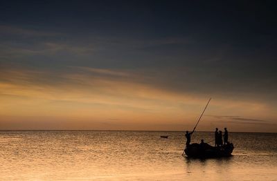 Boat sailing in sea at sunset