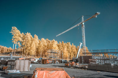 Cranes at construction site against sky