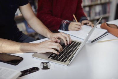 Students using laptop and taking notes