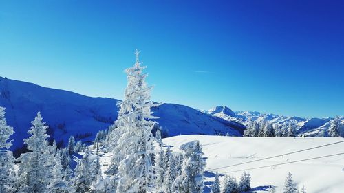 Low angle view of frozen mountain against clear blue sky