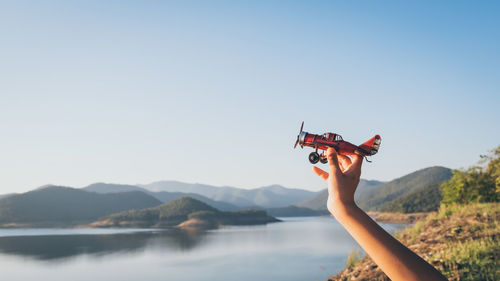 Cropped hand holding toy airplane